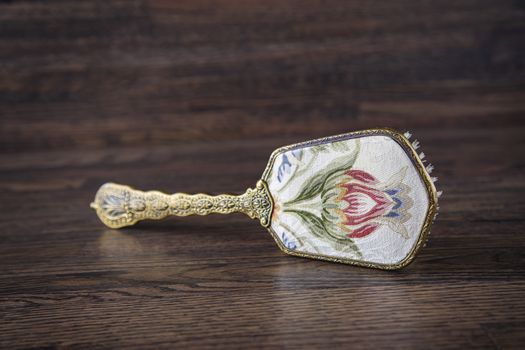 Back of an antique hair brush on a dark oak wood background