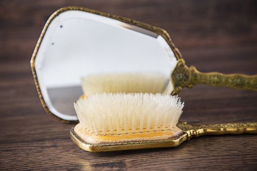 Vintage hair brush reflecting on a vintage hand mirror
