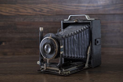 Antique medium format camera against a dark brown oak wood background