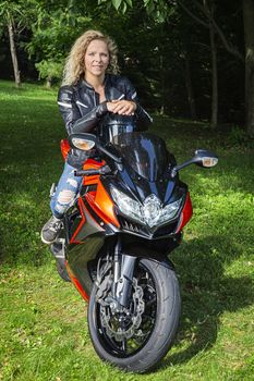 Young woman sitting on her sport motocycle with an expression of questionning