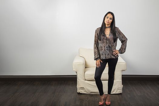 twenty something young woman, standing in front of a couch, with a look of annoyance