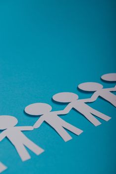 abstract paper people holding for hands on blue background