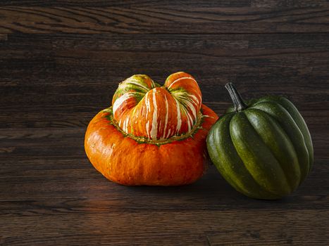 Turban and sweet dumbling squash against a dark wood background