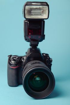 Professional modern DSLR camera against blue background