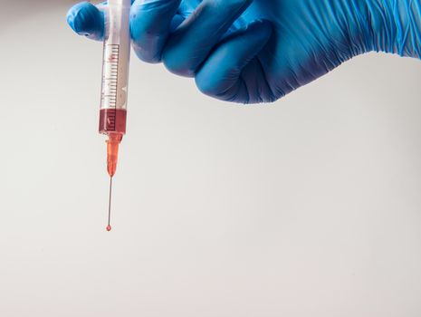 Hand in glove with syringe on white background. Injections.