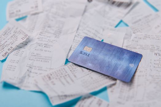 Close-up Of Credit Card On Shopping Receipt On Blue Background