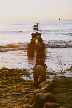 Breakwaters in the Baltic sea over the sunset in summer