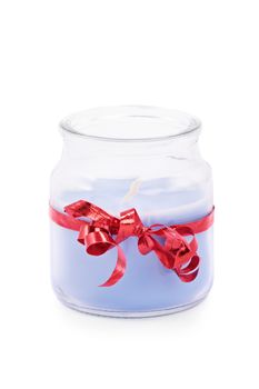 Close up shot of a cute blue candle in a jar wrapped with red ribbon, isolated on white background.

