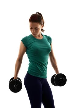 Fit attractive young woman working out with a set of dumbbells, looking down, with a dramatic light, isolated on white background. Fitness and healthy lifestyle concept.