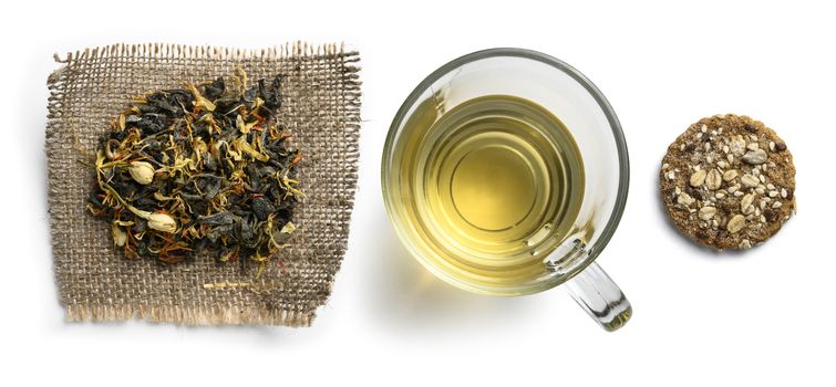 Green tea with natural aromatic additives and a Cup of tea. Top view on white background.