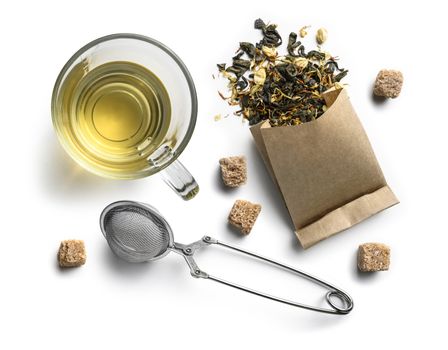 Green tea with natural aromatic additives and a Cup of tea. Top view on white background.