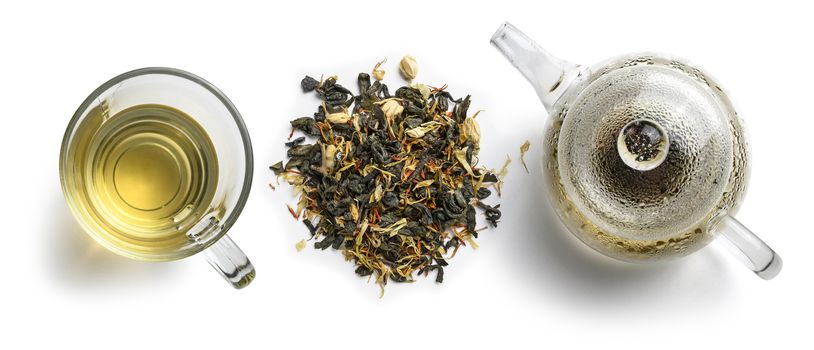 Green tea with natural aromatic additives and a teapot. Top view on white background.