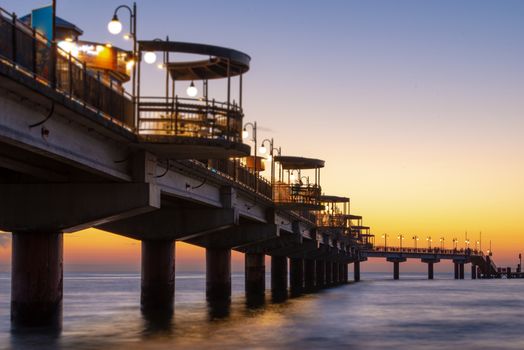 Baltic sea at beautiful sunset in Miedzyzdroje beach, city where the festival of stars takes place every year . Polish baltic coast. Famous city among the tourist. Pier at sunset