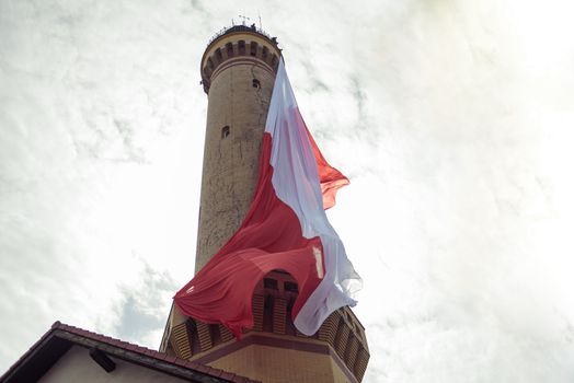 Polish flag hung on at historical lighthouse located in Swinoujscie, Poland, The construction was build in 1828 and height is 65 meters. 19th century. Top tallest Lighthouse in the World
