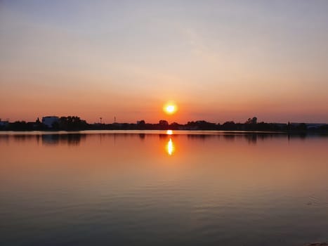 View of sunset over the lake with orange sky in the background