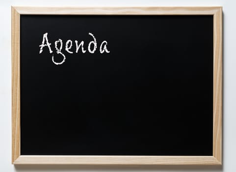 a blackboard with written.  the word Agenda
