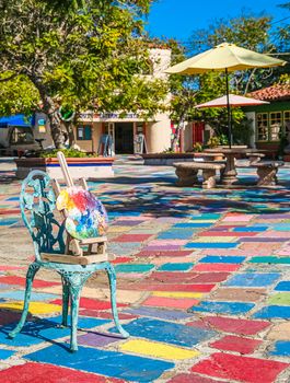 Artist Palette in Chair in Colorful Courtyard