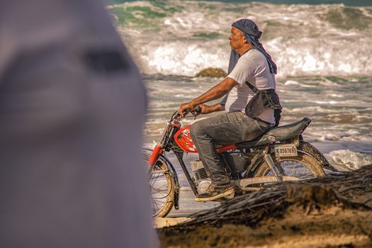 PLAYA LIMON, DOMINICAN REPUBLIC 28 DECEMBER 2019: Biker on the Caribbean beach