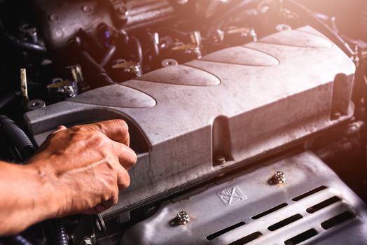 Hand of auto mechanic technician service engine and open the engine oil lid on car in garage