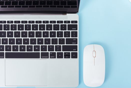 Top view laptop computer notebook and wireless mouse isolated on blue background