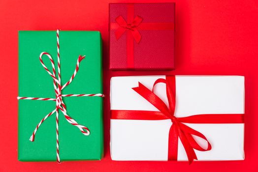 Happy New Year and Christmas 2020 day, top view Xmas multi color gift boxes on red background with copy space for your text