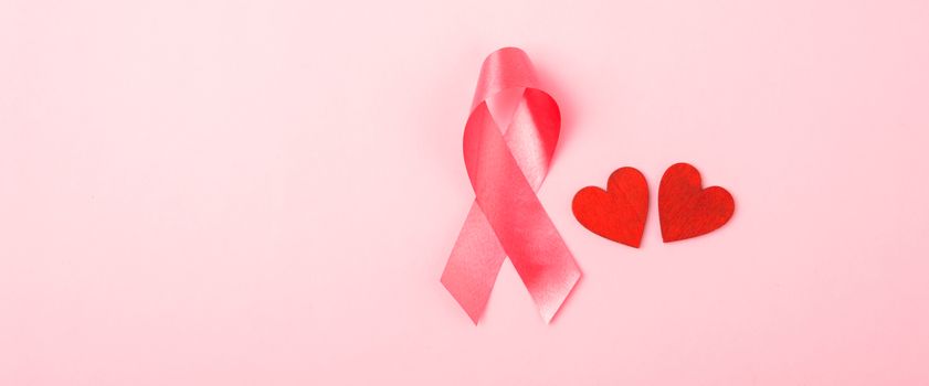 Breast cancer month health concept, flat lay top view, put pink ribbon and Red Heart on pink background with copy space for your text