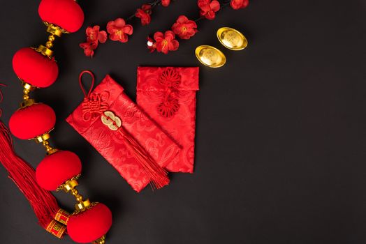 Chinese new year concept, flat lay top view, Happy Chinese new year with Red envelope and gold ingot (Character "FU" means fortune, blessing, wealth) on black background with copy space for your text