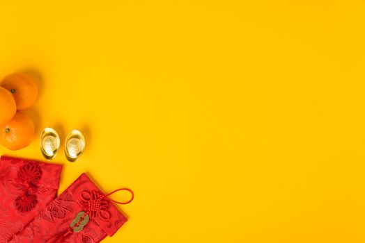 Chinese new year festival concept, flat lay top view, Happy Chinese new year with Red envelope and gold ingot (Character "FU" means fortune, blessing) on yellow background with copy space for text