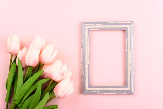 Happy Women's Day, Mother's Day concept. top view flat lay photo frame and Tulip flower on pink background, copy space for your text