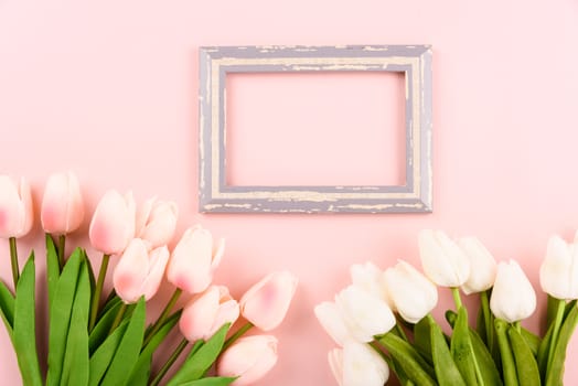 Happy Women's Day, Mother's Day concept. top view flat lay photo frame and Tulip flower on pink background, copy space for your text