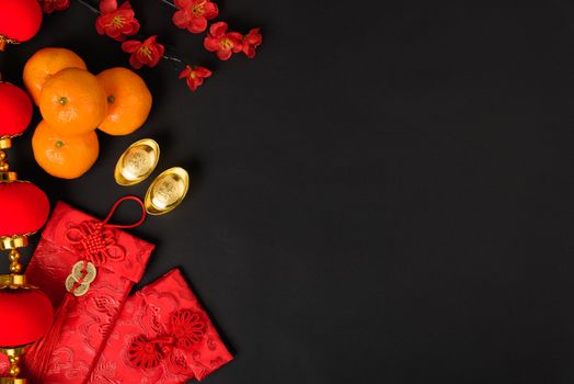 Chinese new year festival concept, flat lay top view, Happy Chinese new year with Red envelope and gold ingot (Character "FU" means fortune, blessing) on black background with copy space for text