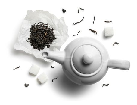 Teapots and tea leaves on a white background. The view from the top.