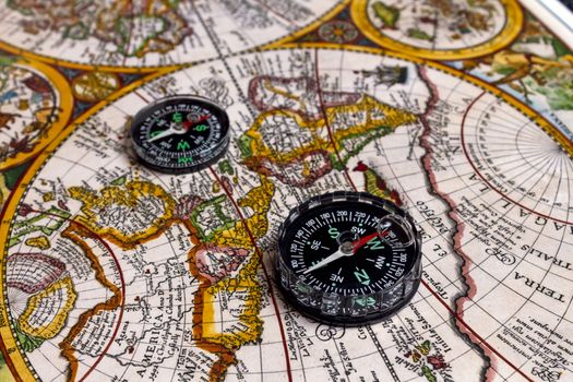 Contemporary compass on vintage world map. Selective focus. 
