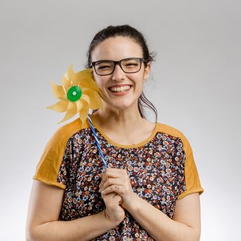 Portrait of a happy woman playing with a windmill