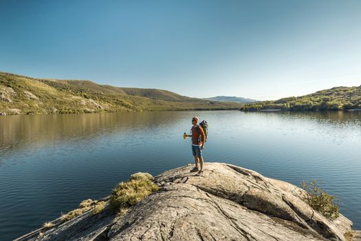 Shot of a man hiking near a beautiful lake