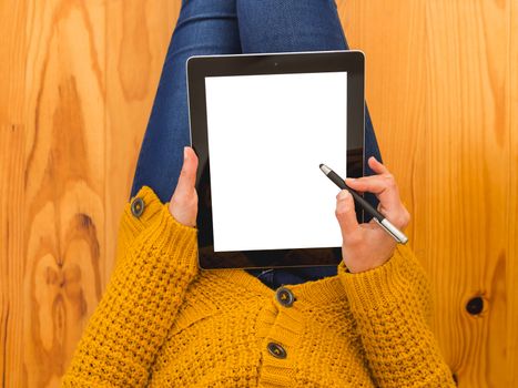 Beautiful woman sitting on the floor working with a tablet 