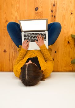 Beautiful woman sitting on the floor working with a tablet 