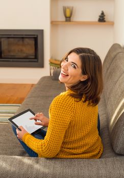 Beautiful young woman working with a tablet at home