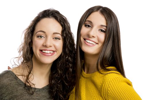 Studio portrait of two beautiful girls smiling