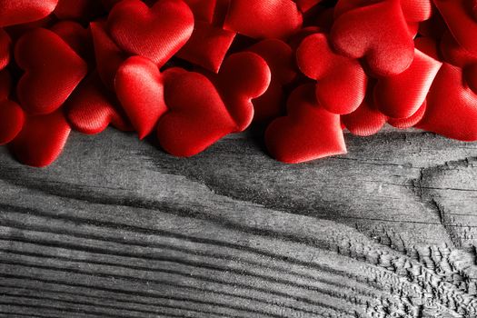 Valentine's day many red silk hearts on wooden background, love concept