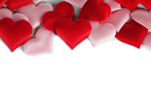 Valentine's day many red and pink silk hearts isolated on white background , border frame with copy space, love concept