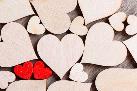 Many wooden colorless hearts background, two red special ones true love concept