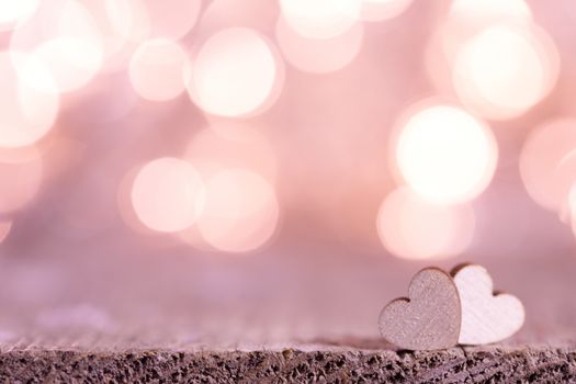 Two handmade wooden hearts on beautiful pink bokeh background. Vintage style. Love Valentine's Day concept.