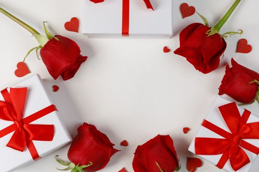 Red rose flowers gifts and red hearts composition on white background top view with copy space. Valentine's day, birthday, wedding, Mother's day concept. Copy space