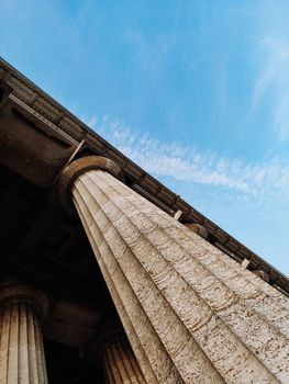 Columns on blue sky background. Vertical photo