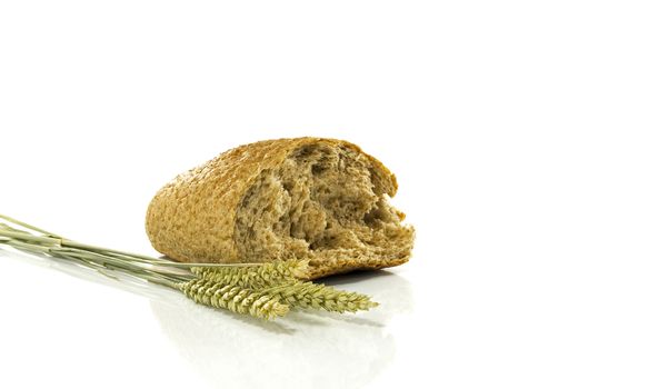 A wheat bread and shock of wheat on a white background