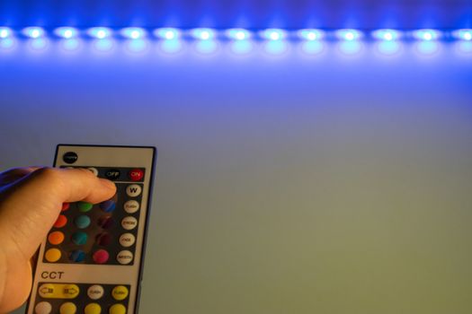 Bucharest / Romania - July 23, 2019: Rgb led remote controller pointing to the led strip.