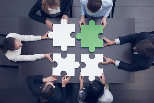 Group of business people assembling jigsaw puzzle, team support and help concept