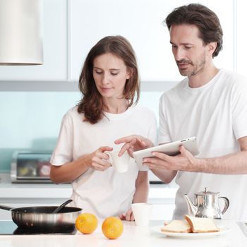 Happy couple cooking breakfast together in the kitchen