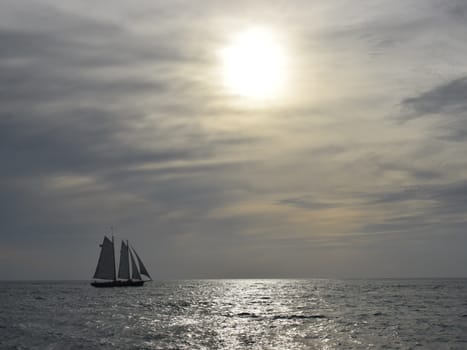 Sailboat on Ocean against Sunset Sky